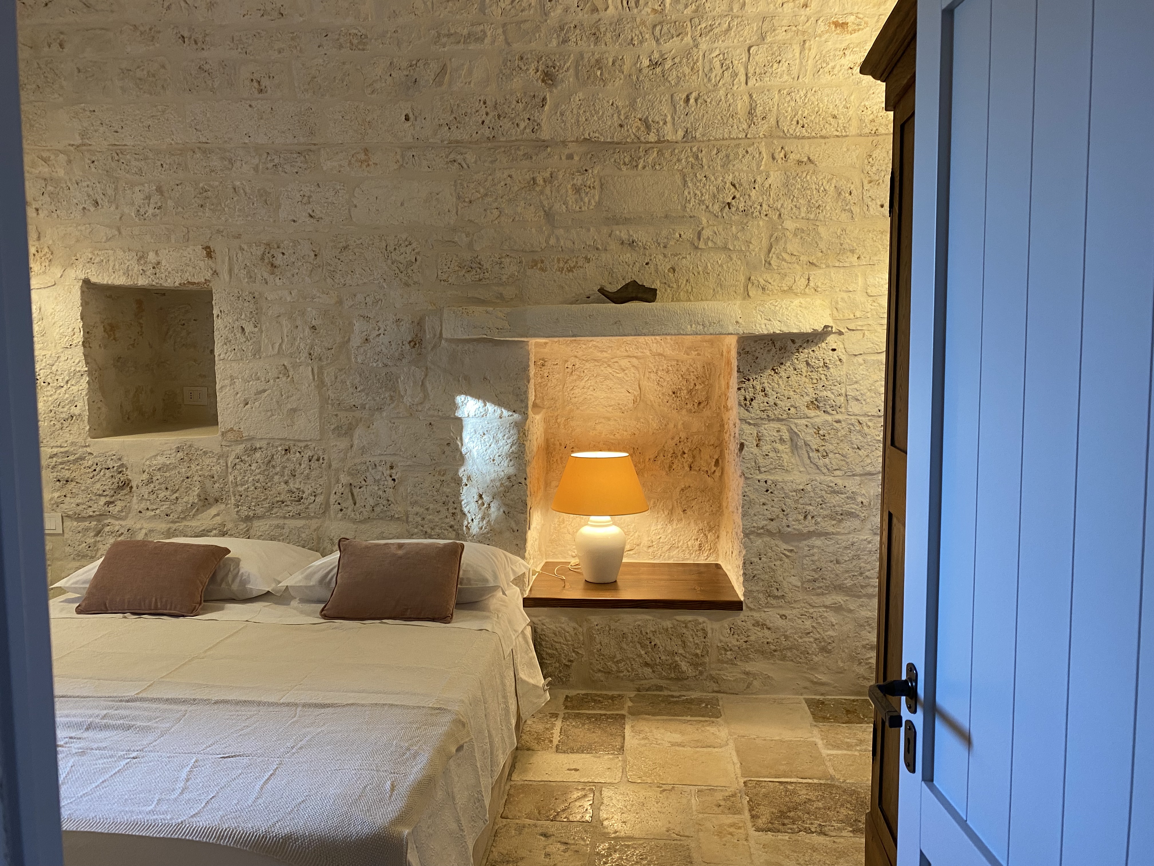 Camera con volta di pietra e letto in lino